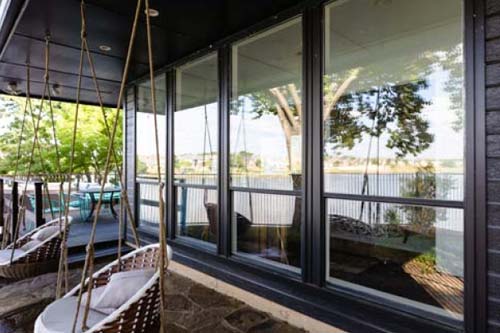 Full wall windows with porch swings in view