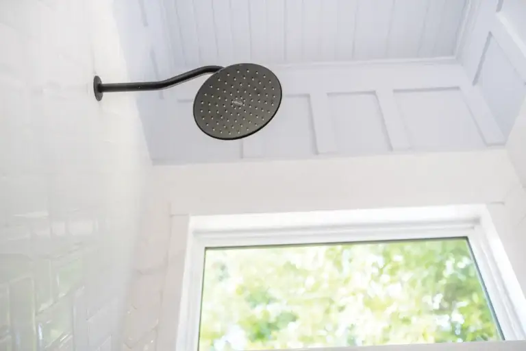 White shower with shower head and window in background